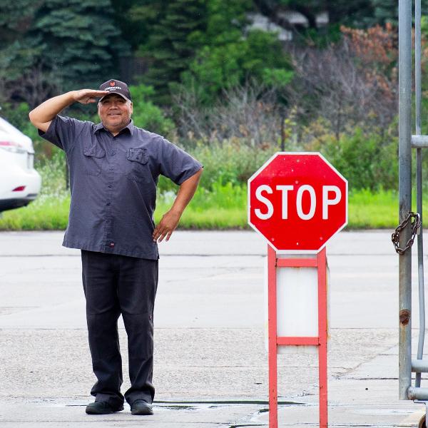 https://www.coremarkmetals.com/files/image/medium/security guard salute near stop entrance sign